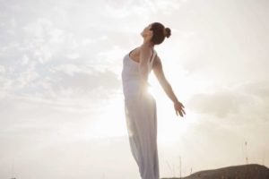 Femme étirement ciel lumineux